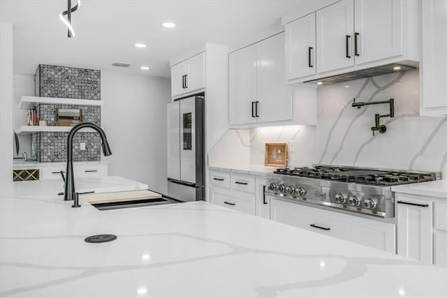 7025 Ashdown Dr, Corpus Christi, TX 78413 - kitchen featuring appliances with stainless steel finishes, backsplash, white cabinetry, light stone counters, and recessed lighting