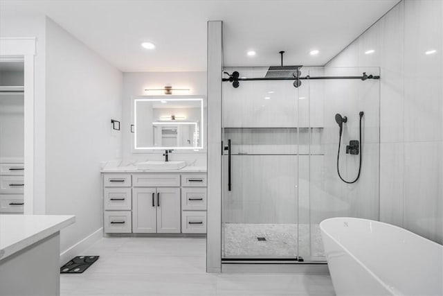 7025 Ashdown Dr, Corpus Christi, TX 78413 - bathroom featuring vanity, a stall shower, a freestanding tub, recessed lighting, and baseboards