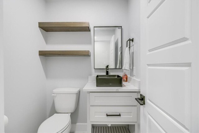 7025 Ashdown Dr, Corpus Christi, TX 78413 - half bathroom featuring toilet, vanity, and baseboards