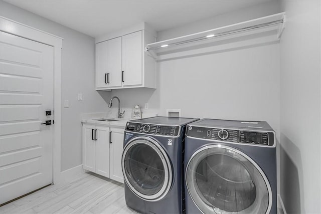 7025 Ashdown Dr, Corpus Christi, TX 78413 - laundry area featuring washing machine and clothes dryer, cabinet space, light wood-type flooring, and baseboards