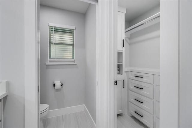 7025 Ashdown Dr, Corpus Christi, TX 78413 - bathroom featuring toilet, baseboards, a spacious closet, and vanity