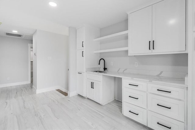 7025 Ashdown Dr, Corpus Christi, TX 78413 - kitchen with a sink, light stone counters, open shelves, white cabinets, and recessed lighting