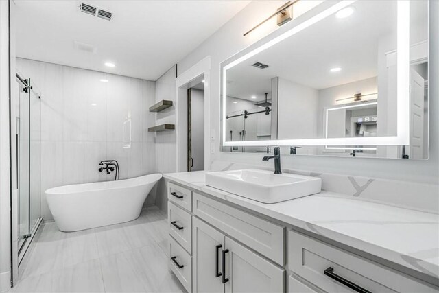 7025 Ashdown Dr, Corpus Christi, TX 78413 - bathroom featuring a soaking tub, vanity, a stall shower, and marble finish floors