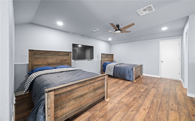 bedroom with hardwood / wood-style flooring, visible vents, and vaulted ceiling