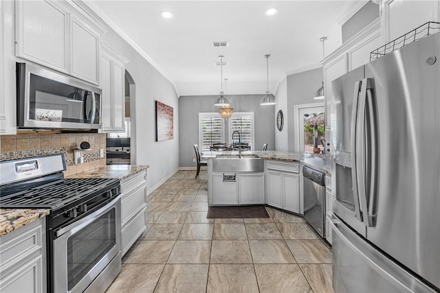 13901 Laffite Dr, Corpus Christi, TX 78418 - kitchen featuring appliances with stainless steel finishes, a peninsula, white cabinets, light stone countertops, and recessed lighting