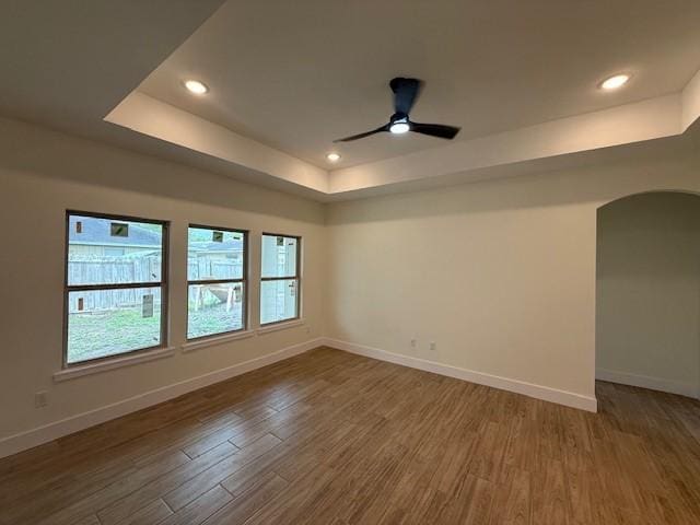 2761 Camargo Dr, Corpus Christi, TX 78415 - empty room with arched walkways, a raised ceiling, wood finished floors, recessed lighting, and a ceiling fan