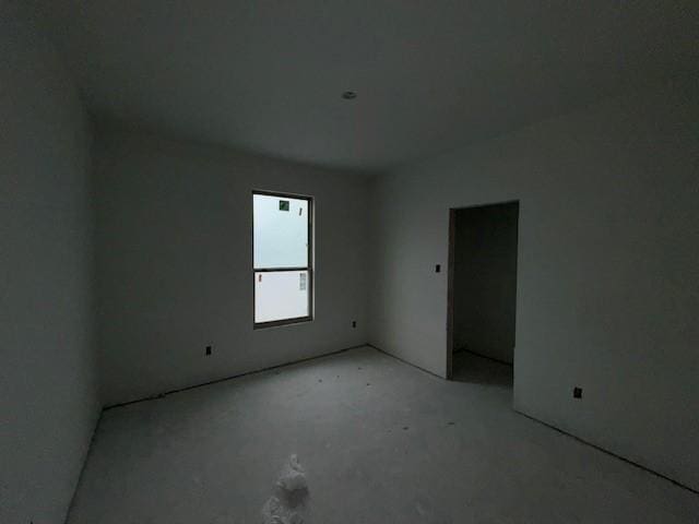 unfurnished room with unfinished concrete flooring