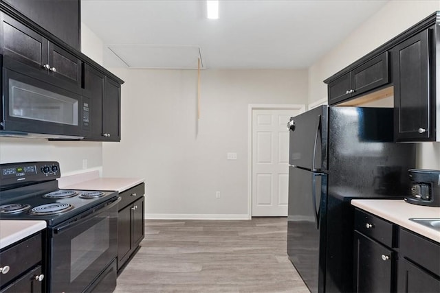 1818 16th St, Rockport, TX 78382 - kitchen featuring dark cabinets, black appliances, light wood-style flooring, and light countertops