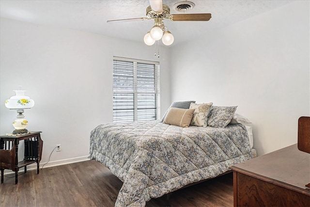 bedroom with visible vents, wood finished floors, a ceiling fan, and baseboards