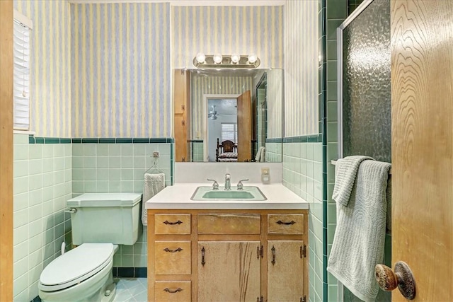 bathroom featuring a wainscoted wall, tile walls, and wallpapered walls