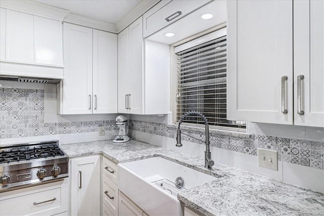 kitchen with stainless steel gas stovetop, white cabinetry, a sink, and backsplash