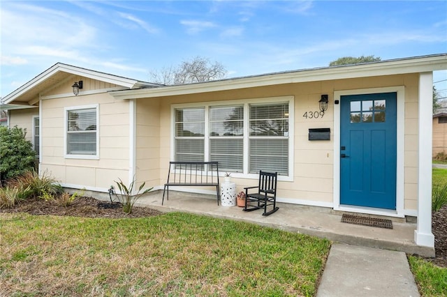 entrance to property with a yard and a porch