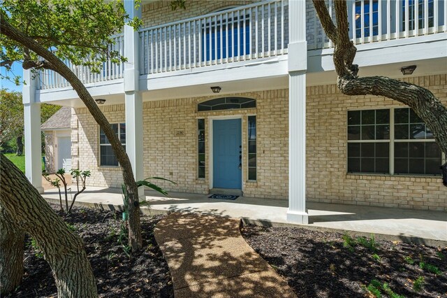 property entrance featuring a balcony and a patio area