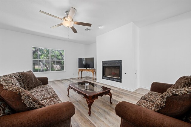 living room with light hardwood / wood-style floors and ceiling fan