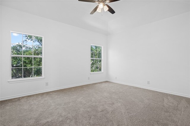 empty room featuring ceiling fan, a healthy amount of sunlight, and carpet flooring