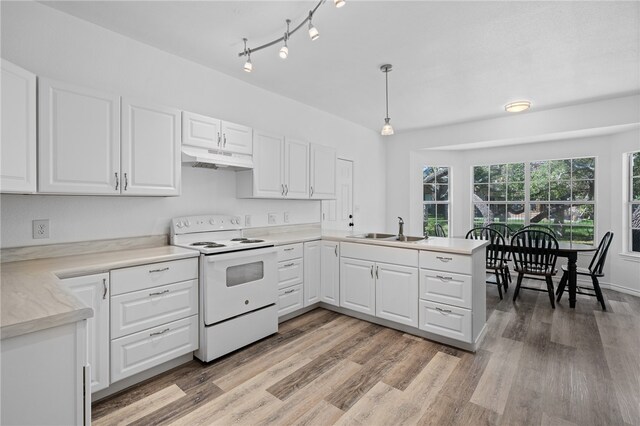 kitchen featuring white electric stove, hanging light fixtures, sink, and white cabinets