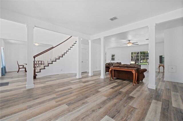 living room with ceiling fan, wood-type flooring, and ornate columns