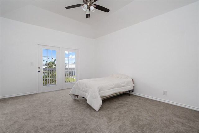 bedroom with a raised ceiling, carpet flooring, ceiling fan, and access to exterior