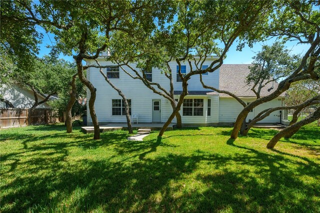 rear view of house with a patio and a lawn