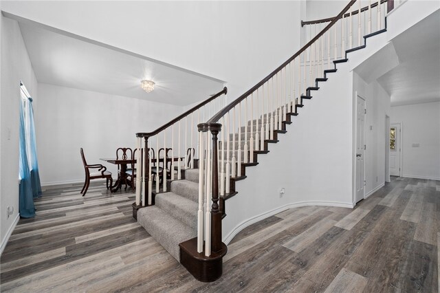 stairway featuring hardwood / wood-style floors and a high ceiling