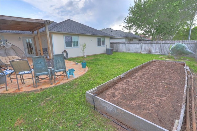 view of yard with a patio, a fenced backyard, central air condition unit, and a vegetable garden