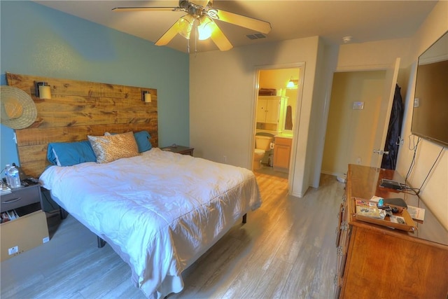 bedroom featuring visible vents, a ceiling fan, light wood-style flooring, and ensuite bath