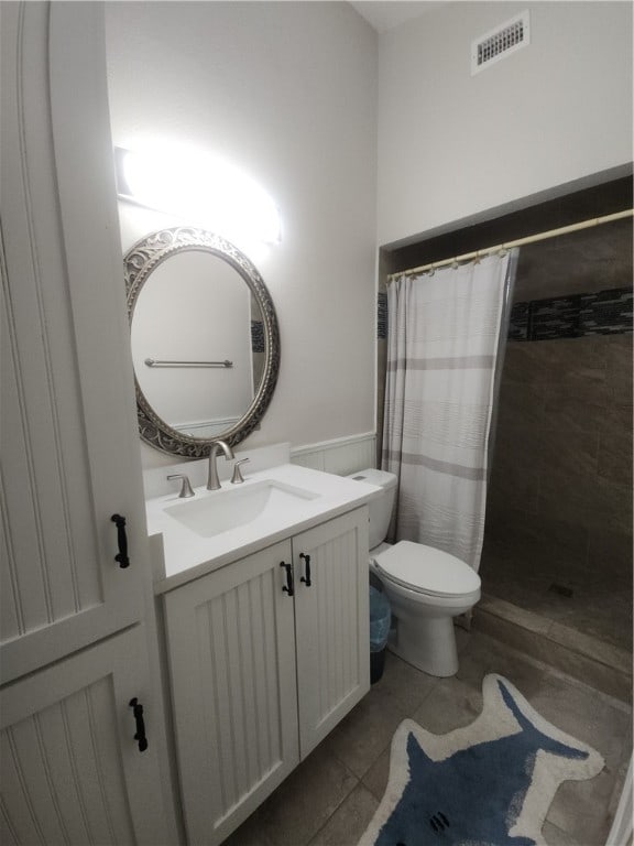 bathroom with walk in shower, vanity, tile patterned floors, and toilet