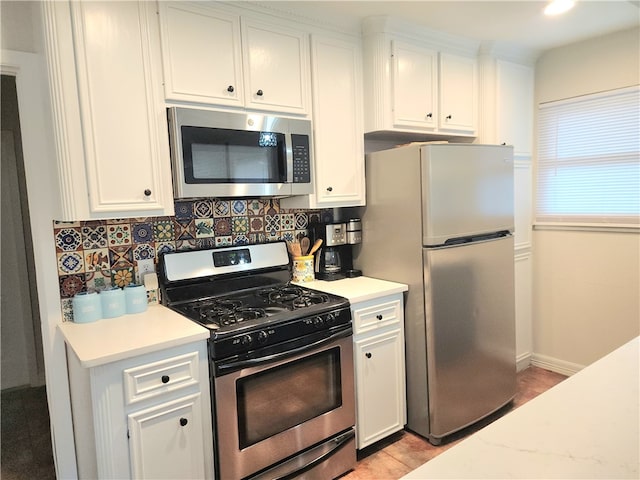 kitchen with white cabinetry, decorative backsplash, light tile patterned floors, and stainless steel appliances