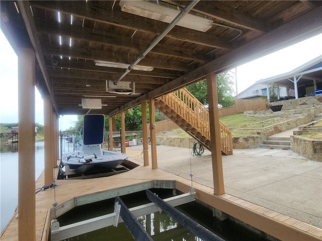 dock area with a patio area and a water view