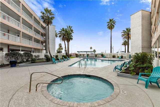 pool featuring a patio, a community hot tub, and fence