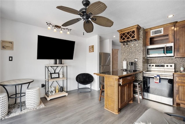 kitchen with tasteful backsplash, visible vents, dark countertops, appliances with stainless steel finishes, and dark wood-type flooring