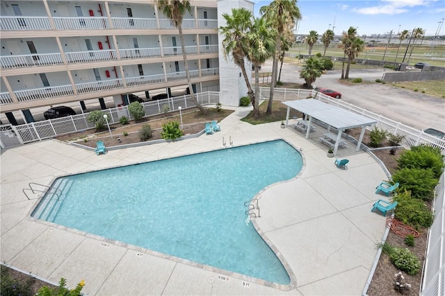 pool with a patio area, fence, and a pergola