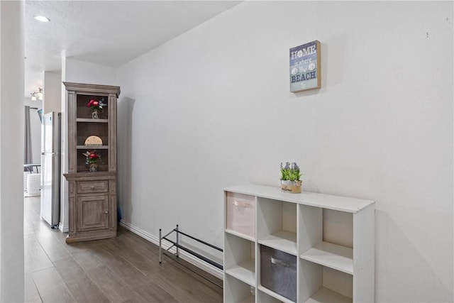 hallway featuring baseboards and wood finished floors