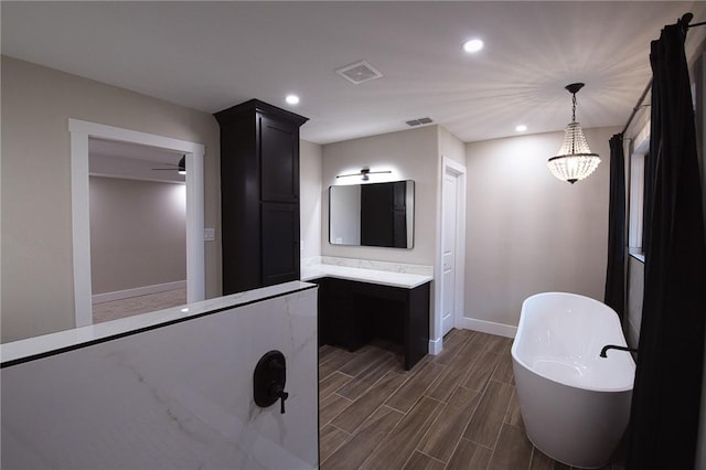 full bath featuring visible vents, a freestanding bath, and recessed lighting