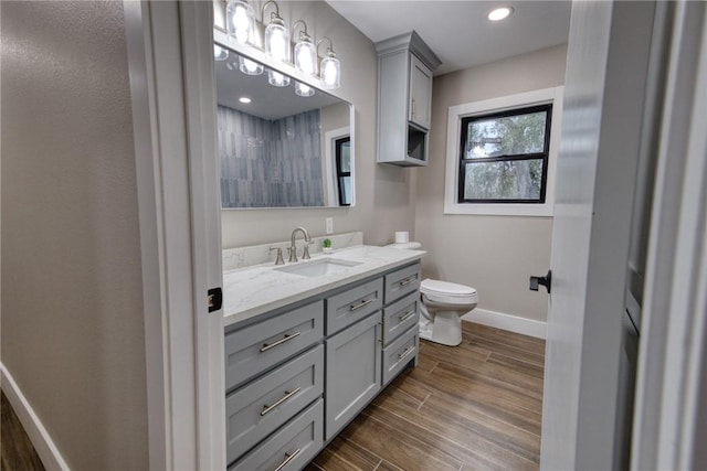 bathroom featuring recessed lighting, toilet, wood tiled floor, vanity, and baseboards