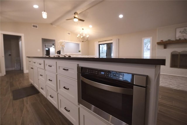 kitchen featuring dark wood-style flooring, dark countertops, lofted ceiling with beams, white cabinetry, and oven