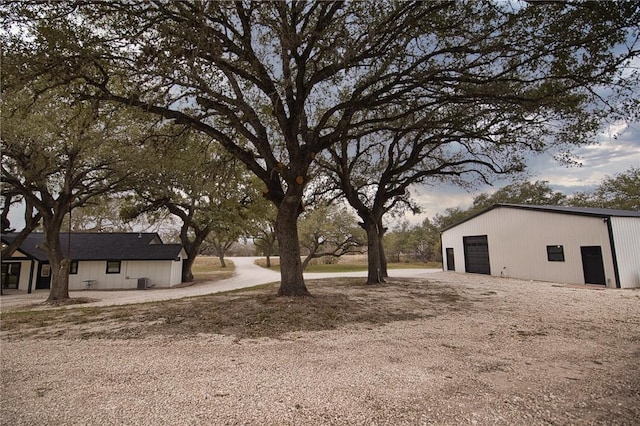 view of yard with a garage and an outbuilding