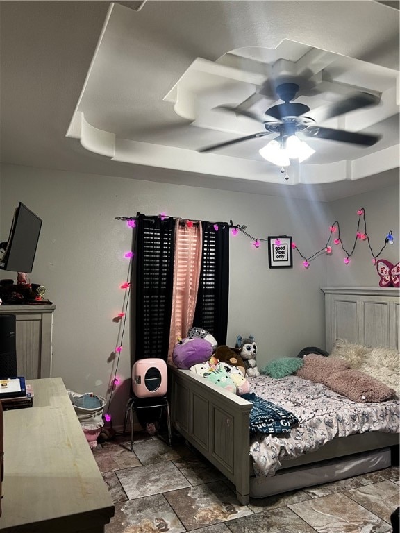 bedroom featuring ceiling fan and a tray ceiling