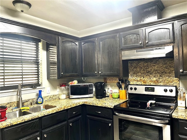 kitchen with decorative backsplash, stainless steel appliances, sink, and light stone countertops