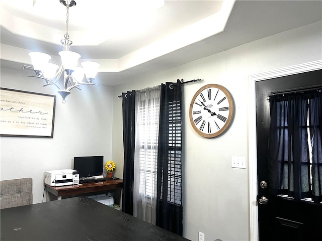 office space featuring a notable chandelier and a tray ceiling