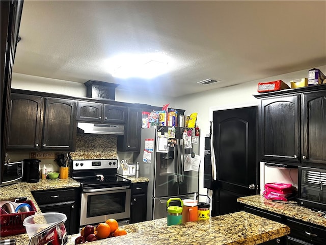 kitchen with tasteful backsplash, light stone countertops, and appliances with stainless steel finishes