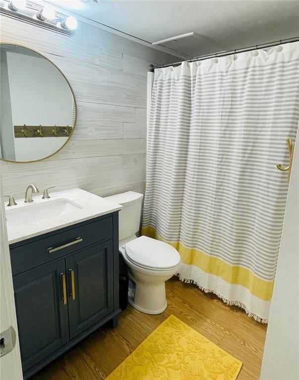 bathroom with wood walls, vanity, hardwood / wood-style flooring, and toilet