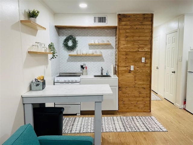 misc room with washer / clothes dryer, sink, and light hardwood / wood-style flooring