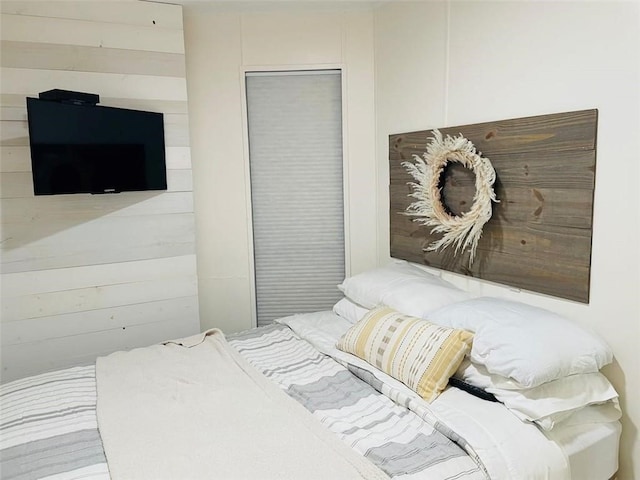 bedroom featuring wooden walls and a closet