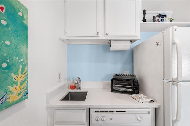 kitchen featuring sink, white appliances, and white cabinets