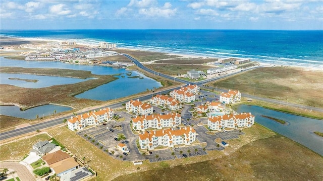 drone / aerial view featuring a water view and a view of the beach