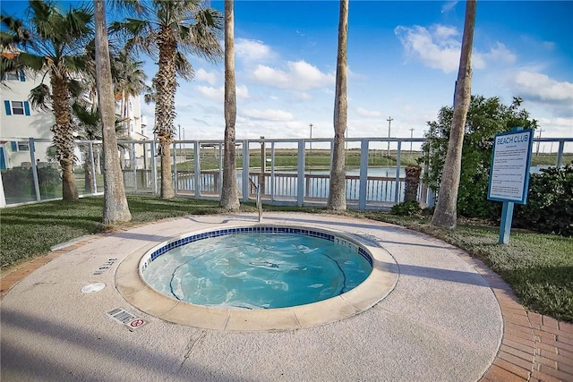 view of swimming pool with a hot tub and a water view