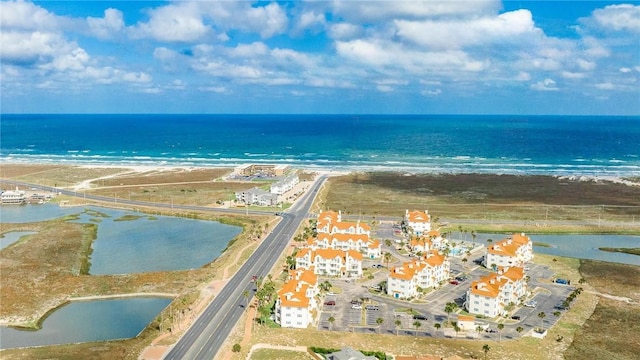 birds eye view of property with a water view and a beach view