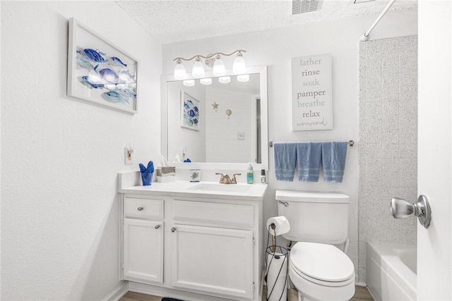 full bathroom featuring vanity, shower / bathing tub combination, a textured ceiling, and toilet