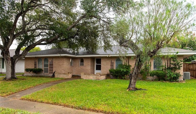 ranch-style home featuring central AC unit and a front yard